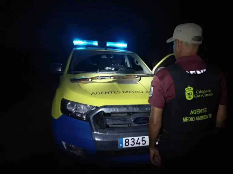 Agente de Medio Ambiente del Cabildo de Gran Canaria junto a un vehículo oficial durante un operativo nocturno
